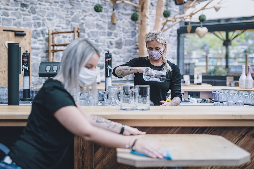 Mitarbeiter eines Lokals in Kaprun tragen während der Coronavirus-Pandemie Schutzmasken