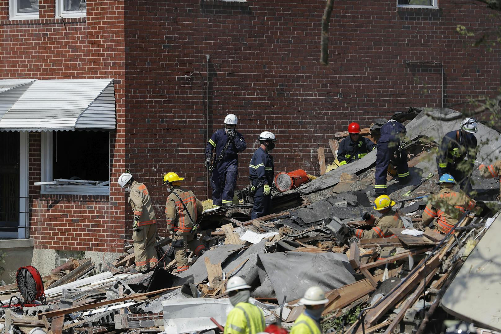 Feuerwehrleute durchsuchen den Trümmerhaufen