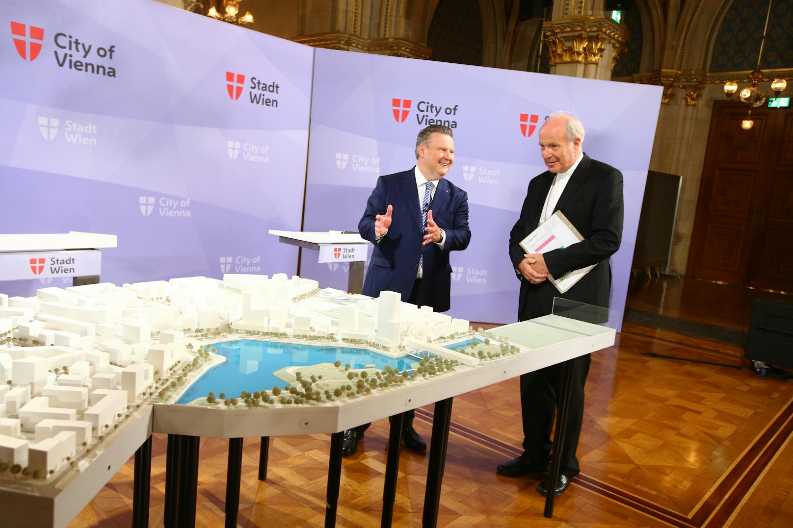Wiens Bürgermeister Michael Ludwig (SPÖ) zeigt Kardinal Christoph Schönborn (re.) ein Modell der Steestadt mit dem Standort für den "Campus der Religionen".