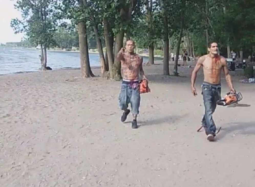 Zwei halbnackte, blutüberströmte Männer mit Kettensägen in den Händen versetzen die Strandbesucher in Panik.