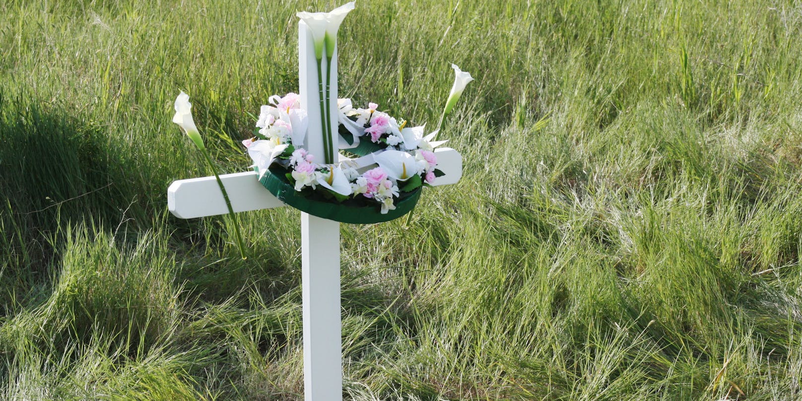 Ein Kreuz mit einem Blumenkranz