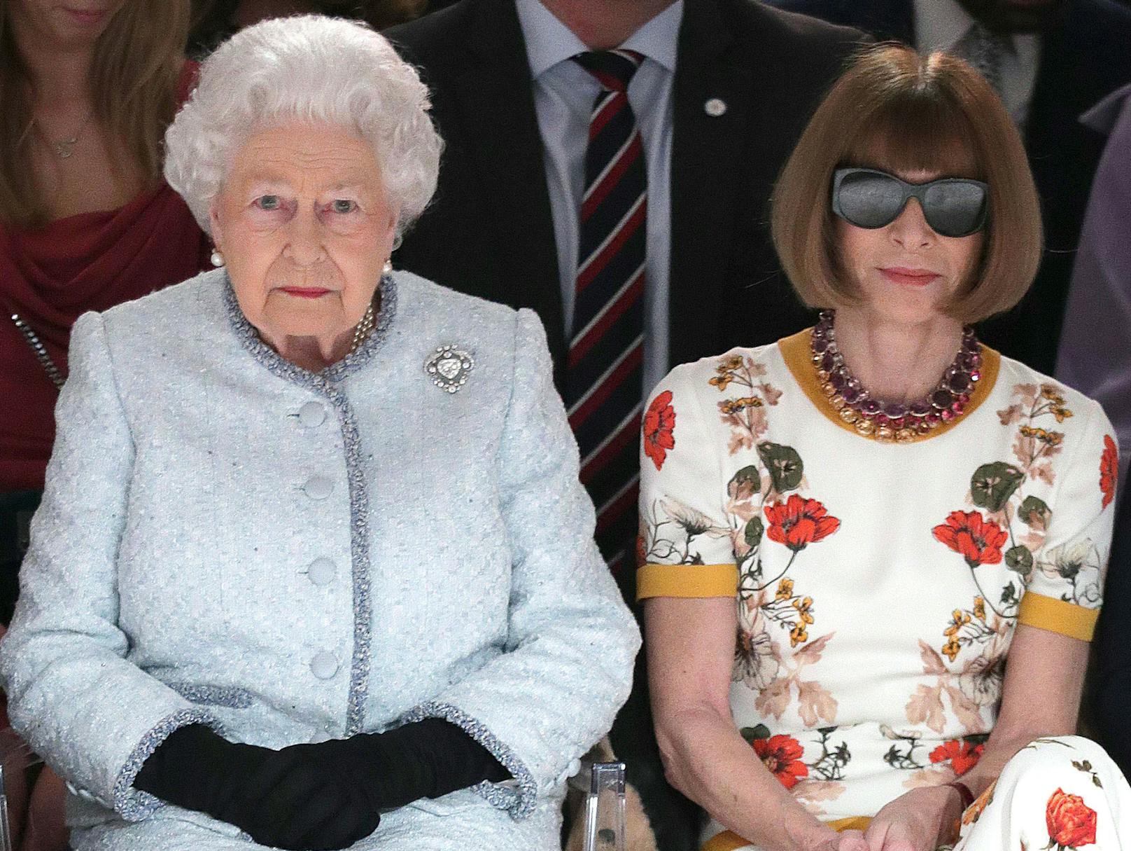 Man sollte meinen, dass sich Vogue-Chefin <strong>Anna Wintour</strong> (re.) mit Stil und Etikette auskennt. Bei der London Fashion Week 2018 durfte sie sogar neben der Königin Platz nehmen.
