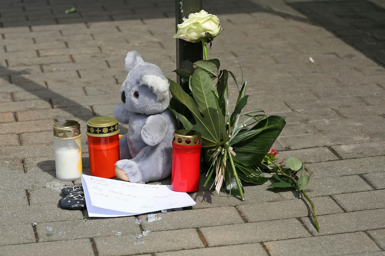 Plüschteddy, Blumen und Kerzen am Unfallort erinnern an den Sechjährigen.