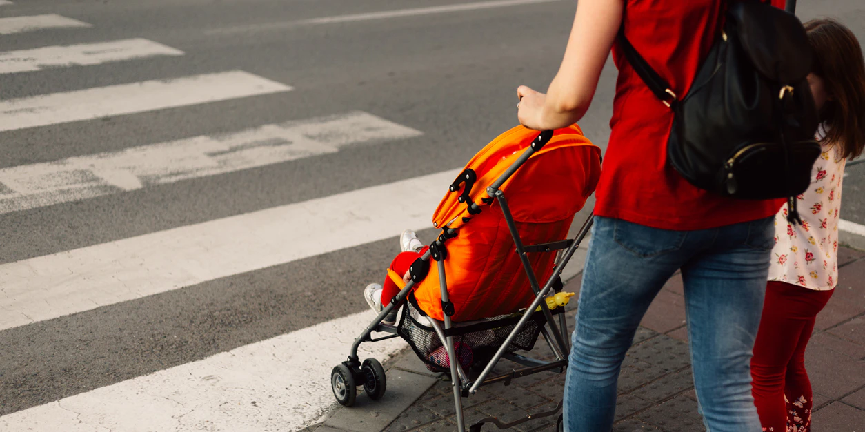 Eine Mutter mit ihren Kindern an einem Zebrastreifen. Symbolbild