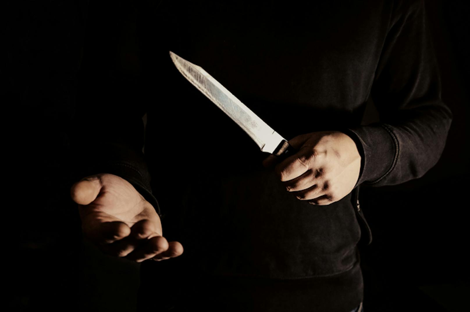 Der dunkel bekleidete Täter forderte mit einem Messer Geld. (Symbolbild).