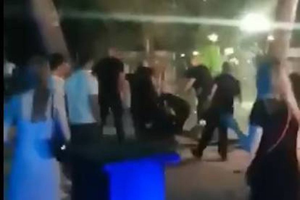 Die Männer schlagen auf die am Boden Liegenden ein.