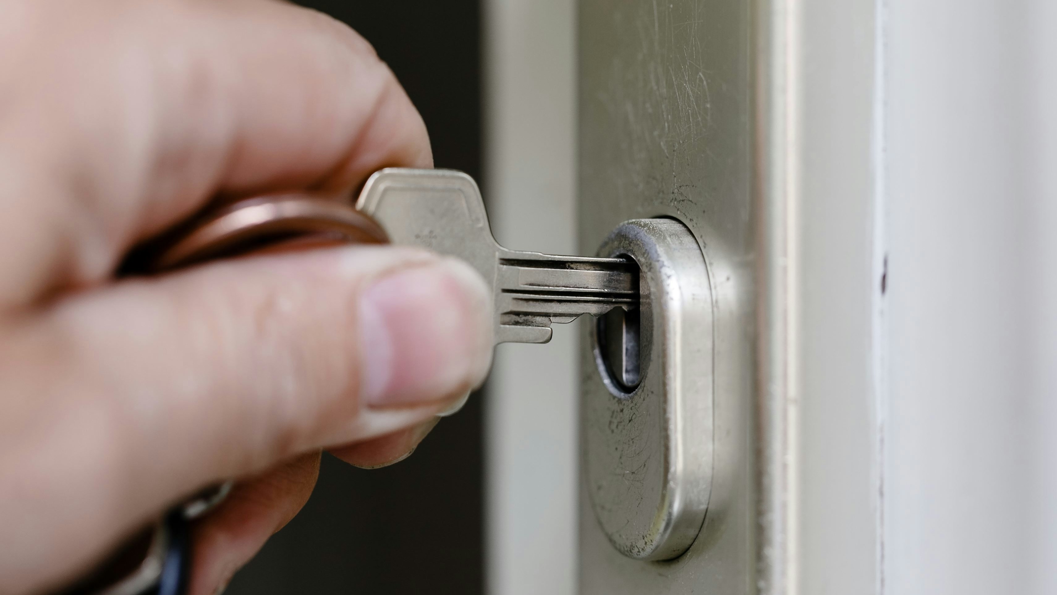 Ein Mann sperrt mit einem Schlüssel seine Wohnungstür. Symbolbild
