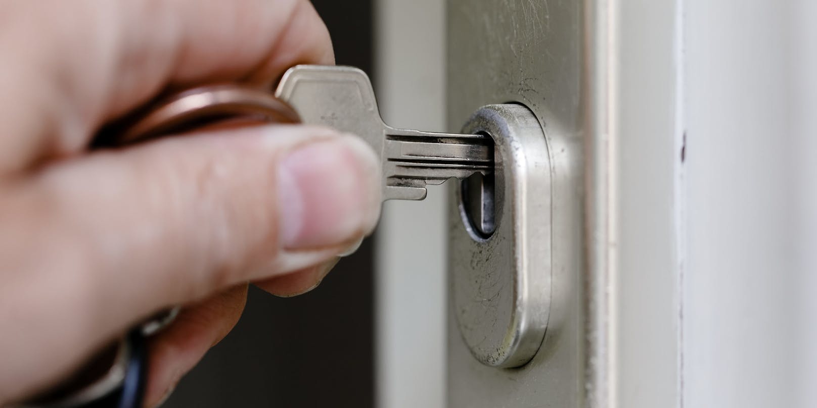 Ein Mann sperrt mit einem Schlüssel seine Wohnungstür. Symbolbild