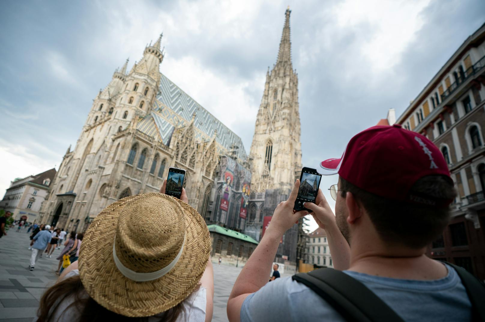Zwei Touristen aus Deutschland fotografieren am 26. Juli 2020 den Stephansdom in Wien. In Zukunft wohl ein seltener Anblick