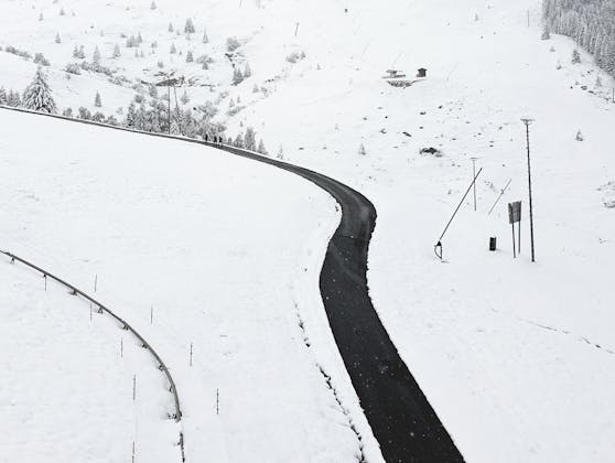 Eine Straße inmitten der verschneiten Landschaft am Samstag, 26. September 2020, in Fiss in Tirol.