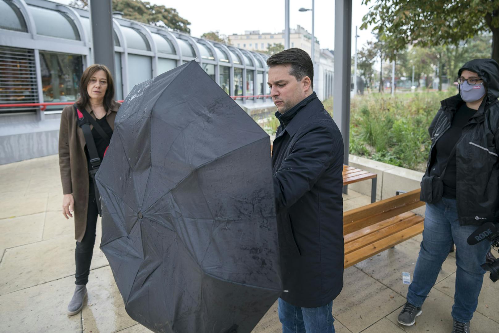 Als ob die Maske nicht schon schlimm genug wäre, muss Nepp am Reumannplatz auch noch mit dem Regenschirm kämpfen. 