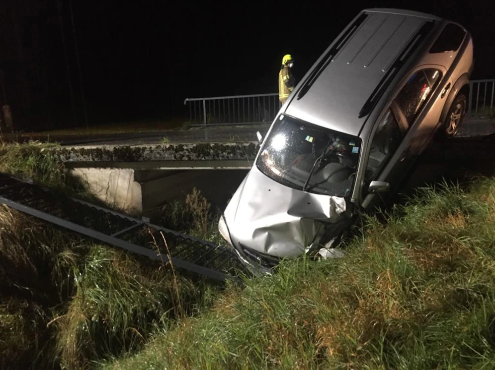 Der Wagen riss noch einen Teil des Geländers mit, bevor das Auto in einem Entwässerungsgraben zum Liegen kam. 