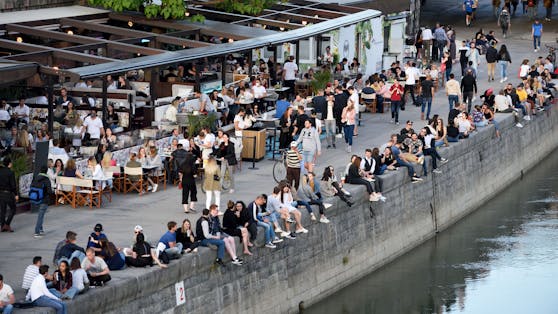 Junge Menschen stürmen bei Schönwetter die Promenaden am Wiener Donaukanal.