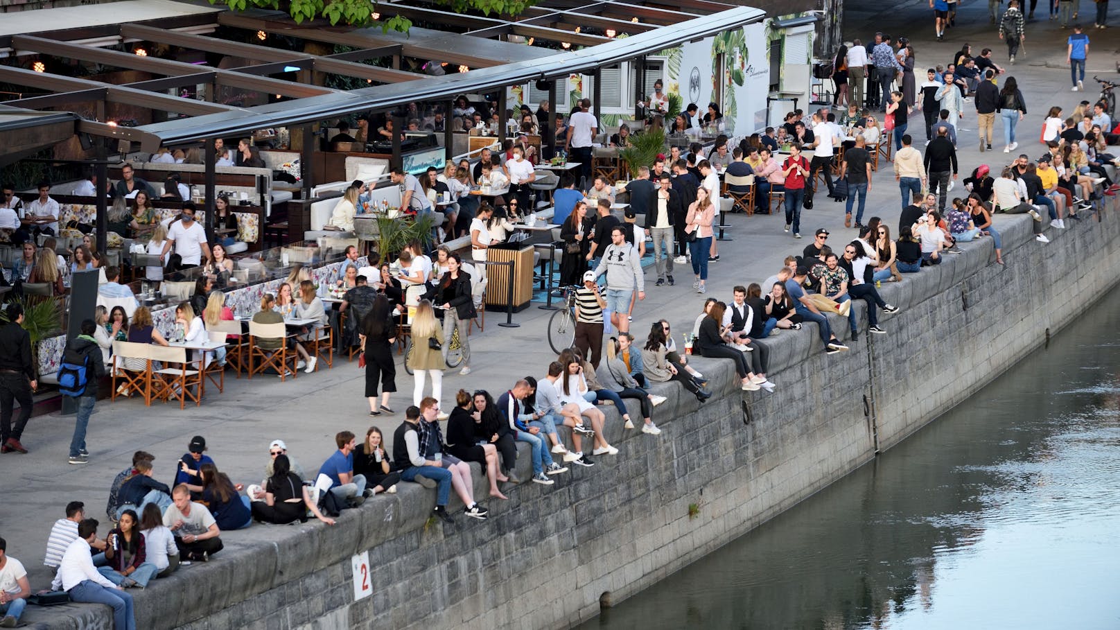 Junge Menschen stürmen bei Schönwetter die Promenaden am Wiener Donaukanal.