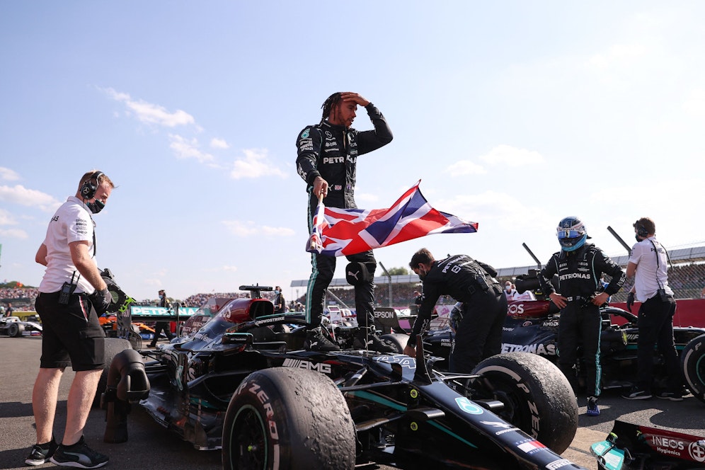 Hamilton feiert mit der britischen Flagge in der Hand.