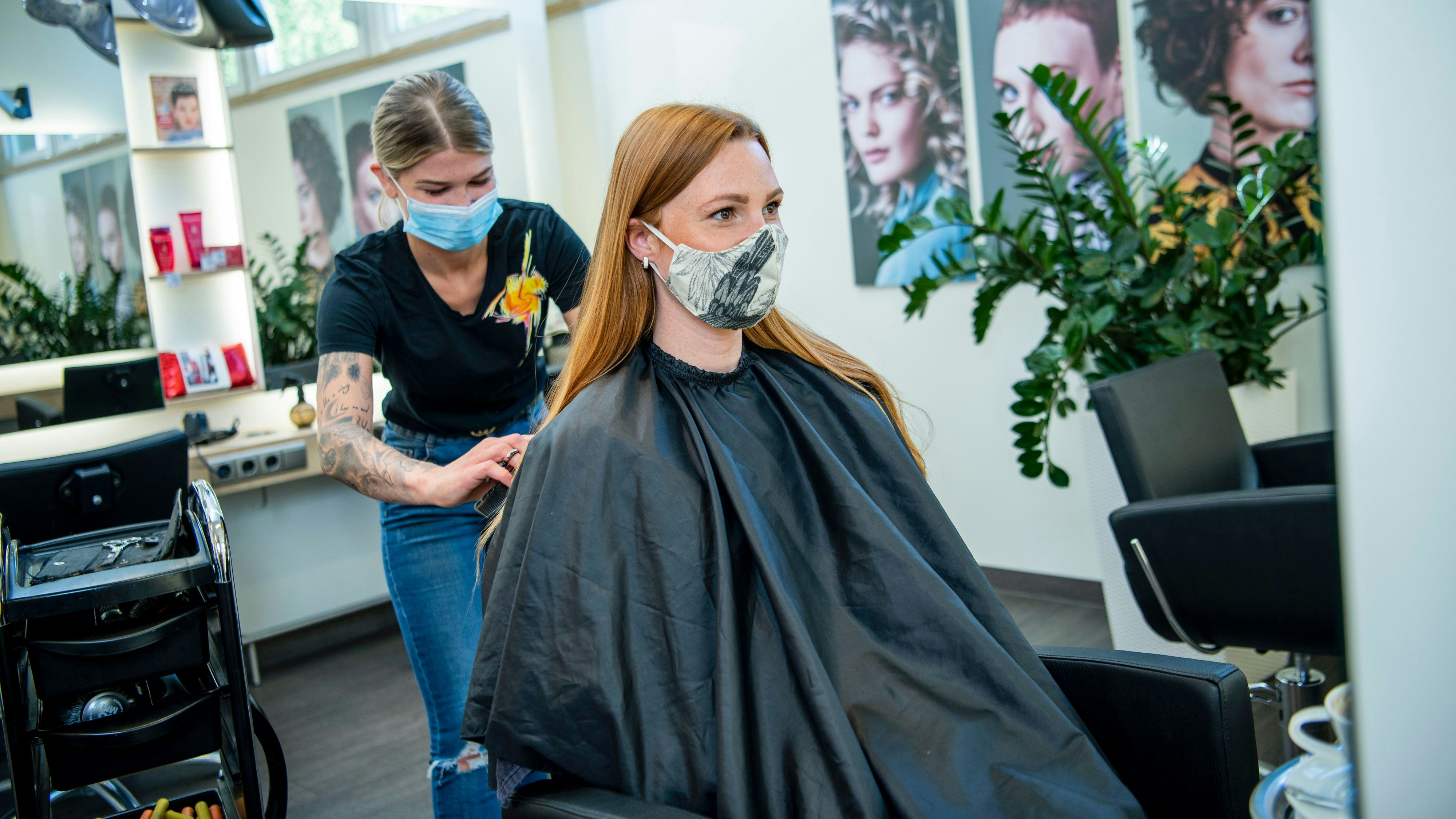 Eine Kundin lässt sich beim Friseur die Haare schneiden.