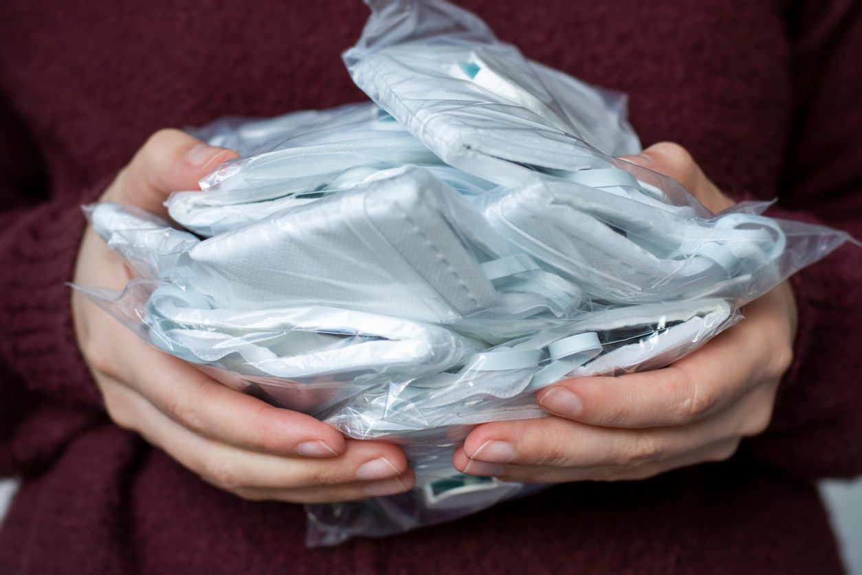 Woman holding a lot of medical face dust filter masks, disposable FFP3 respirators in packaging. Concept of coronavirus, air pollution, virus, flu and infectious diseases. A stock face mouth masks