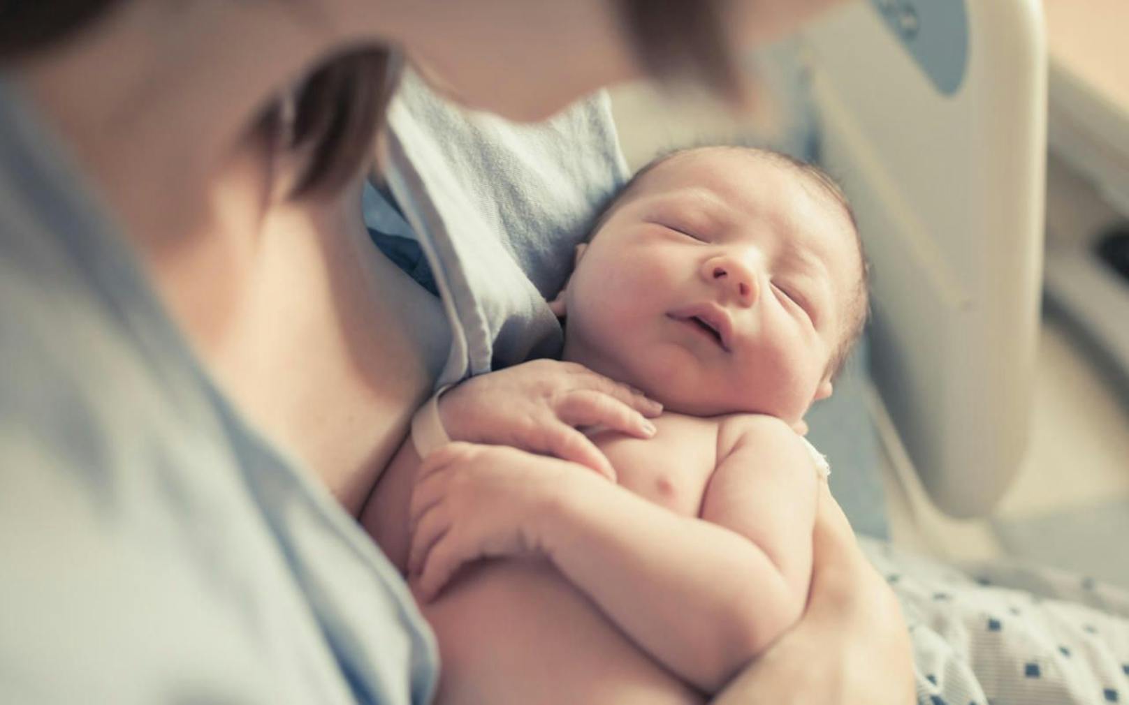 Ein Neugeborenes in den Armen seiner Mutter. Symbolbild.