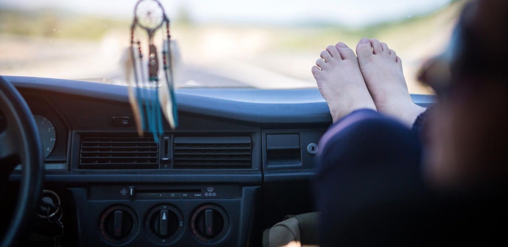 Eine Mutter warnt davor, die Füße auf das Armaturenbrett zu legen.