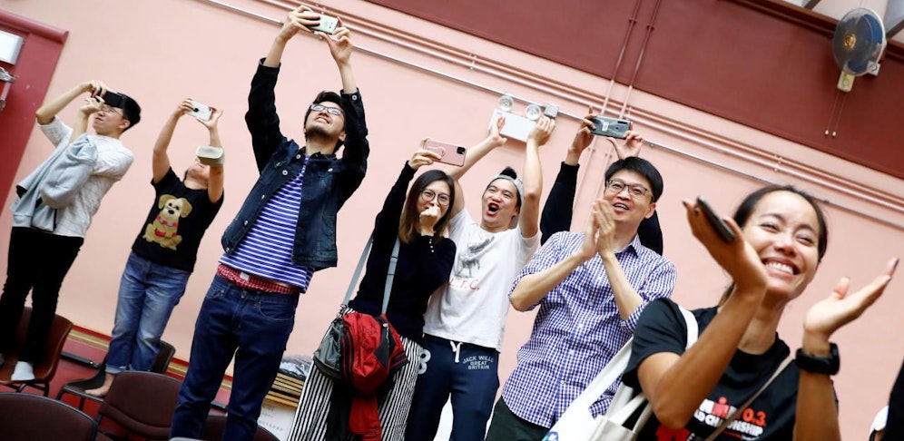Unterstützer des Kandidaten Kelvin Lam im Bezirk South Horizons West jubeln über das Ergebnis.