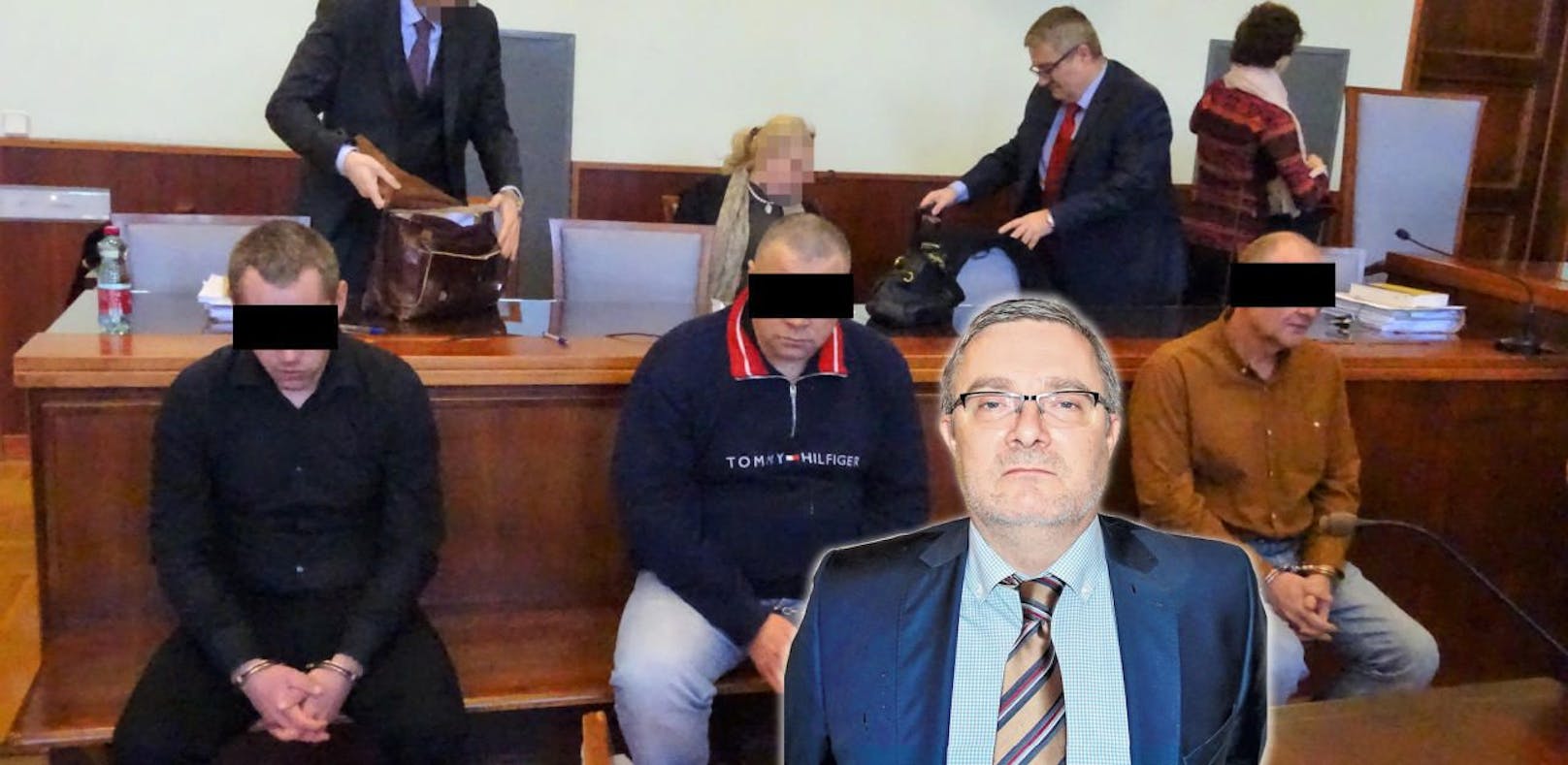 Die Angeklagten vor Gericht, vorne ins Bild geschnitten Anwalt Friis.