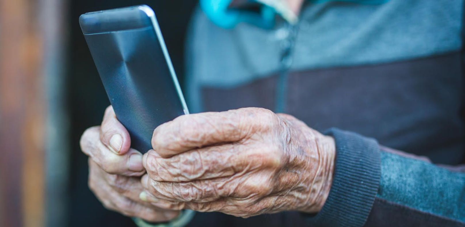Symbolfoto eines alten Mannes mit Handy.