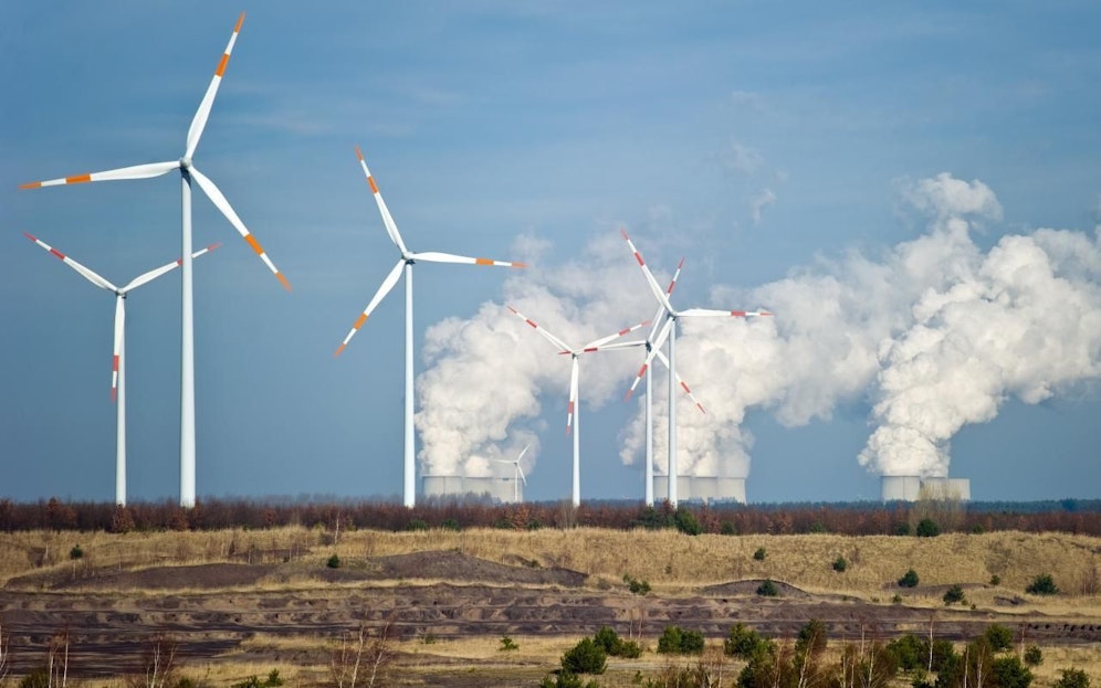 Windturbinen vor dem größten Braunkohlekraftwerk Deutschlands in Jänschwalde. Mit einem CO2-Ausstoß von 23,3 Millionen Tonnen verursachte das Kraftwerk im Jahr 2015 die vierthöchsten Treibhausgasemissionen aller europäischen Kraftwerke.