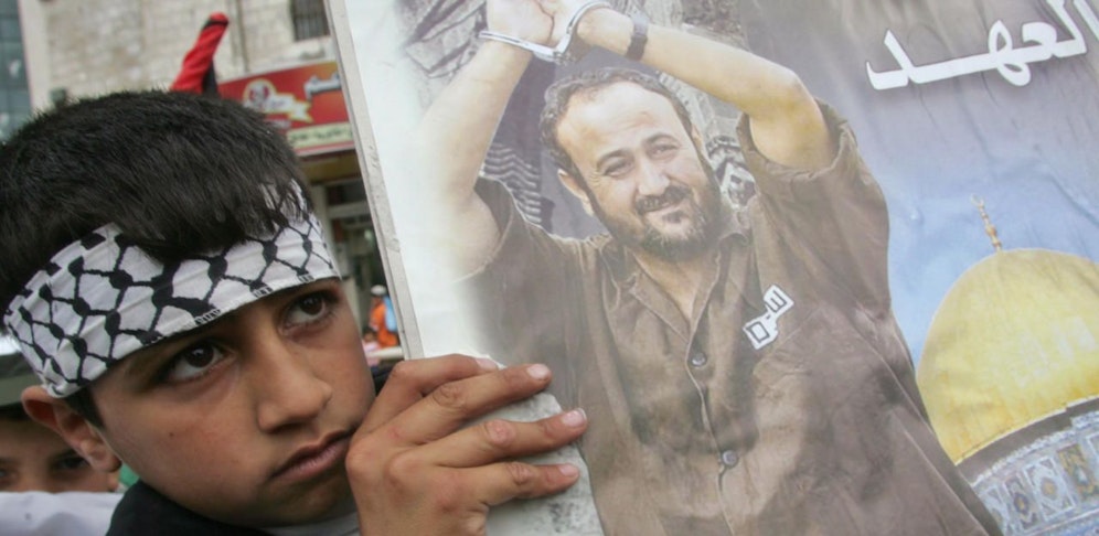 Ein palästinensischer Bub hält ein Bild von Marwan Barghuti während einer Demonstration in die Hand.