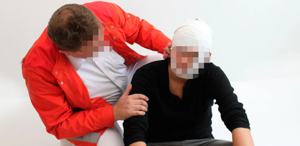 Sanitäter verarztet Betrunkenen.