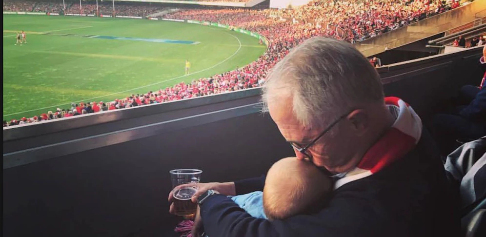 Premier Malcolm Turnbull mit seinem Enkelkind und Bier im Stadion. 