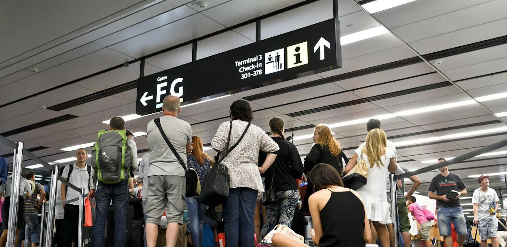 Flugpassagiere vor den Check-In Schaltern des Flughafen Wien-Schwechat.