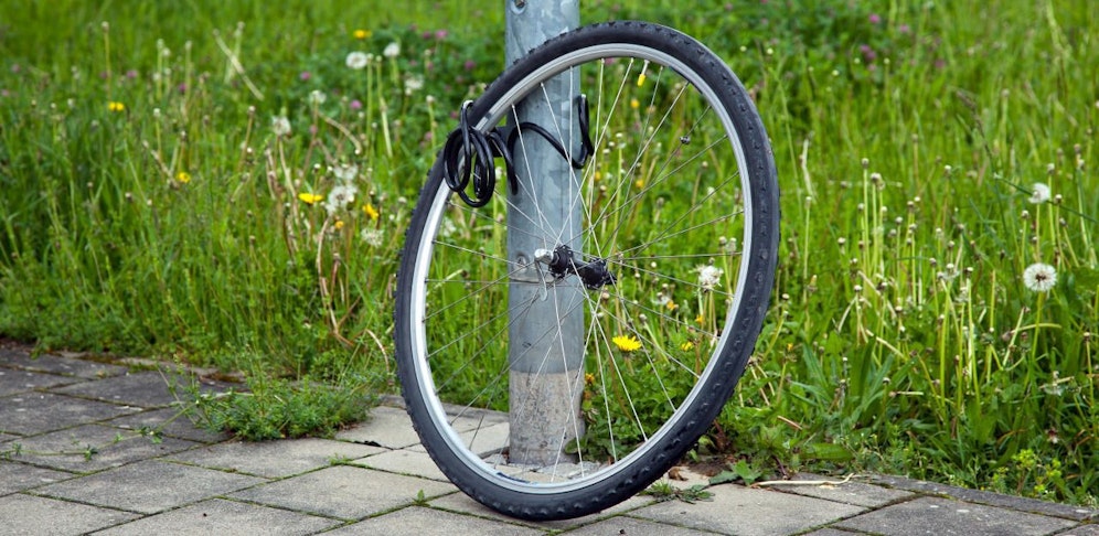 Immer auch Fahrrad-Rahmen mit einem Schloss an einem unbeweglichen Objekt sichern.