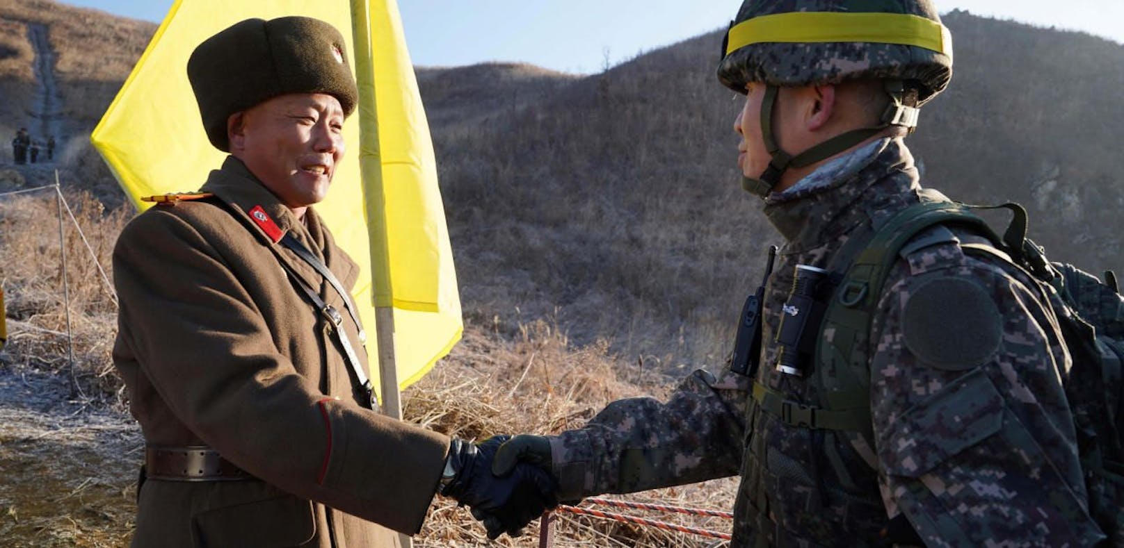 Ein Offizier Nordkoreas (li.) reicht einem Südkoreaner die Hand.