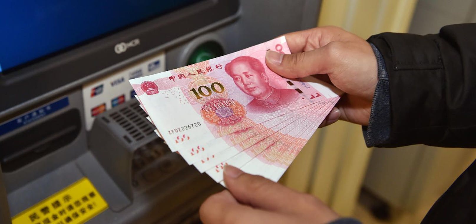 Ein Bankomat in China gibt 100-Yuan-Scheine heraus. Symbolfoto