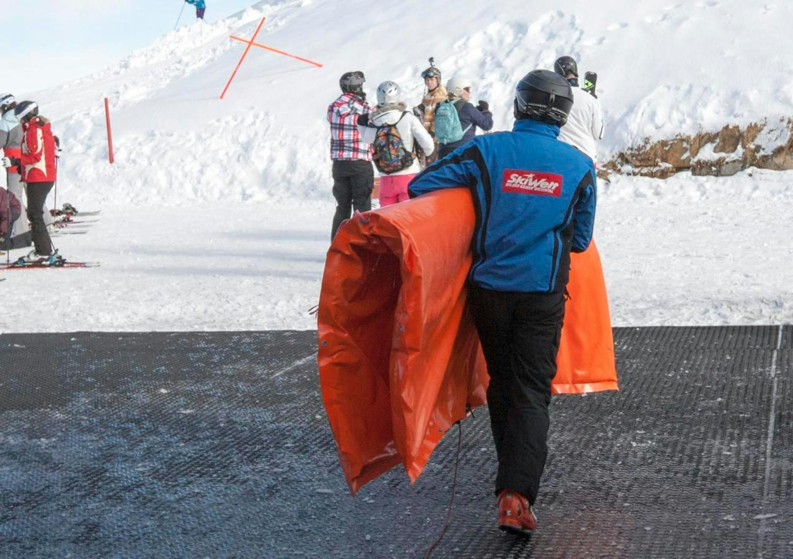 Ein Mann trägt eine Pistenschutzmatte in der Skiwelt Wilder Kaiser. Symbolfoto