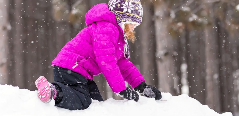 Das Mädchen rutschte von einem Schneehaufen in das Fahrzeug