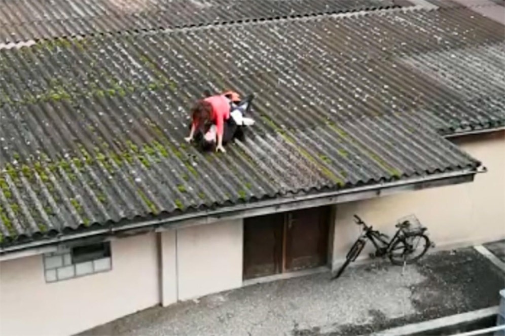 Stelldichein in luftiger Höhe: Ein Pärchen vergnügt sich auf einem Hausdach mitten im Dorfzentrum.