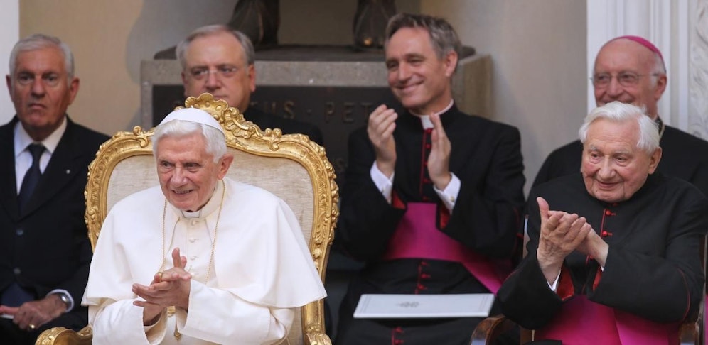 Papst Benedikt XVI. und sein Bruder Georg Ratzinger (r.) klatschen am Freitag (03.08.2012) in der päpstlichen Sommerresidenz in Castel Gandolfo (Italien), im Hintergrund der Privatsekretär von Joseph Ratzinger, Georg Gänswein.
