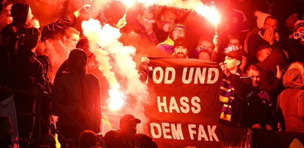 Bosnien-Fans halten einen "Tod und Hass dem FAK"-Banner und Bengalen im Wiener Happel-Stadion.