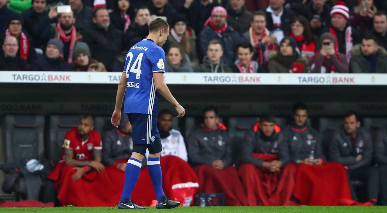Football Soccer - Bayern Munich v Schalke 04 - German Cup (DFB Pokal) - Allianz Arena Munich, Germany - 1/3/17 - Schalke 04's Holger Badstuber walks past the bench of Bayern Munich after being sent off by a yellow-red card.             REUTERS/Michael Dalder      DFB RULES PROHIBIT USE IN MMS SERVICES VIA HANDHELD DEVICES UNTIL TWO HOURS AFTER A MATCH AND ANY USAGE ON INTERNET OR ONLINE MEDIA SIMULATING VIDEO FOOTAGE DURING THE MATCH. - RTS111F8