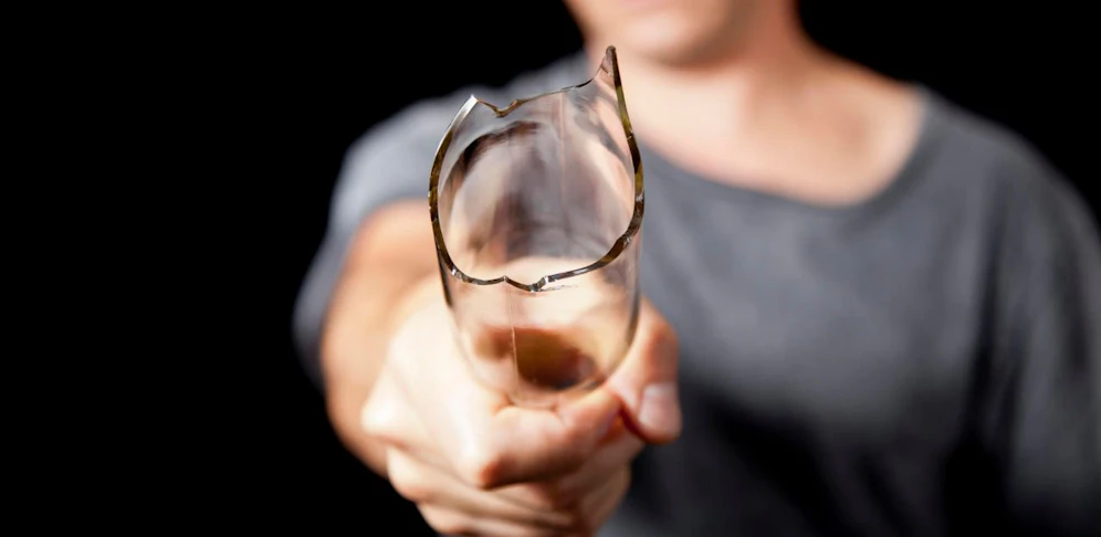 Ein Mann droht mit einer abgebrochenen Glasflasche. Symbolfoto.