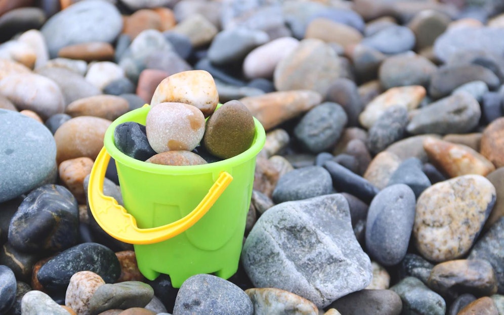 Ein Kübel voller Kieselsteine. Symbolfoto. 