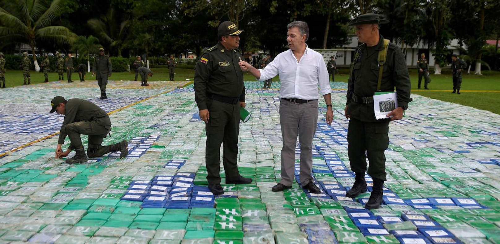 Kolumbiens Präsident Juan Manuel Santos (Mitte) begutachtet die 12 Tonnen Kokain unter seinen Füßen in Apartado.