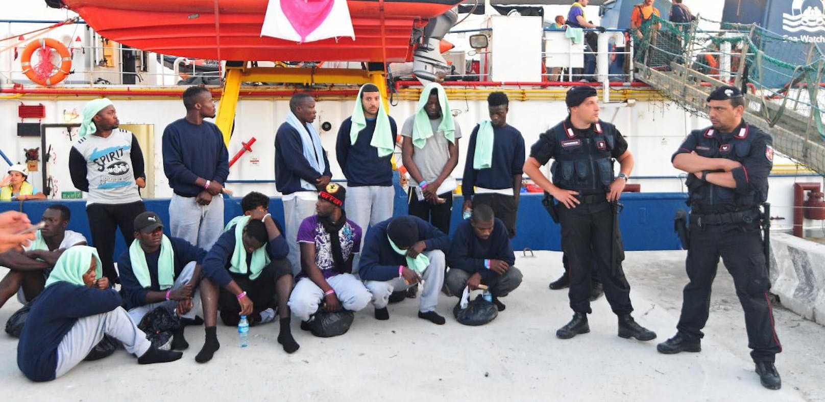 Polizisten nehmen die Migranten der Sea Watch 3 entgegen.
