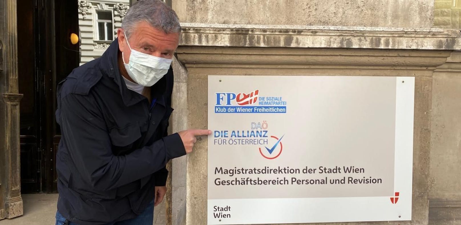 PR-Berater Gernot Rumpold, vorbildlich mit Maske, zeigt das neue Türschild der DAÖ-Zentrale. Die FPÖ residiert jetzt einen Stock höher.