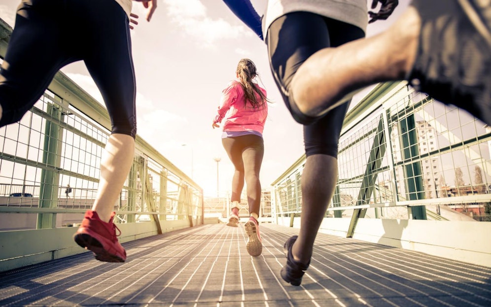 Three runners sprinting outdoors - Sportive people training in a urban area, healthy lifestyle and sport concepts