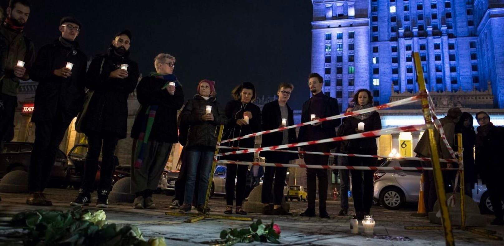 Menschen zünden vor dem Kulturpalast in Warschau Kerzen an. Hier steckte sich der Mann selbst in Brand.
