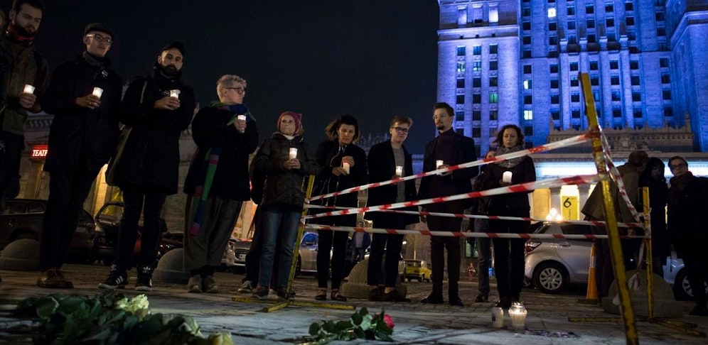 Menschen zünden vor dem Kulturpalast in Warschau Kerzen an. Hier steckte sich der Mann selbst in Brand.
