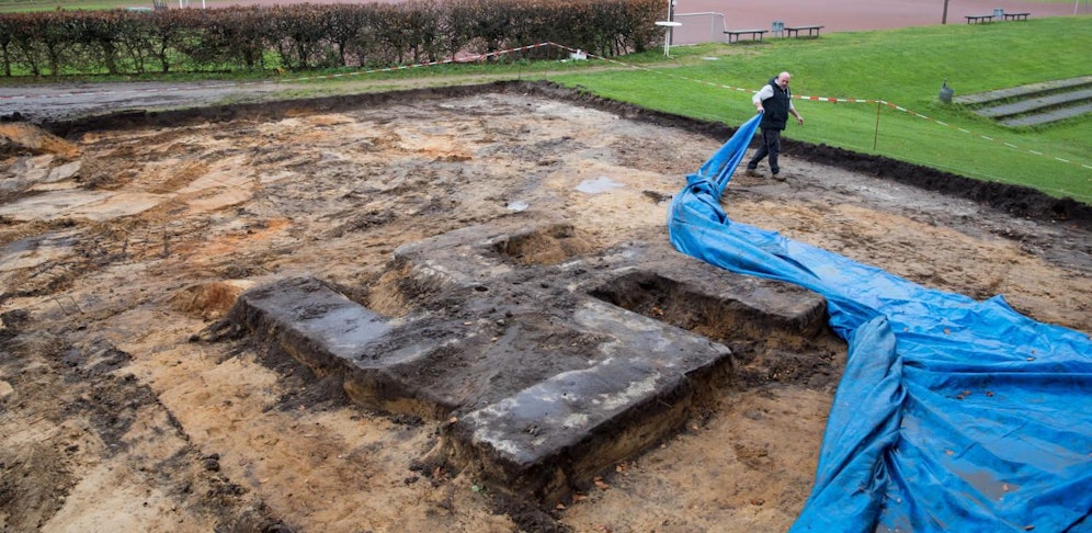 Ein Platzwart entfernt am 21.11.2017 im Hein-Kling Stadion in Hamburg-Billstedt eine Abdeckplane von einem Hakenkreuz aus Beton neben dem Sportplatz. Bei Bauarbeiten für neue Umkleidekabinen auf dem Hamburger Sportplatz ist ein Baggerfahrer auf das riesige Hakenkreuz gestoßen. Das Hakenkreuz aus Beton ist vier mal vier Meter groß und diente in der NS-Zeit als Fundament für ein großes Denkmal.