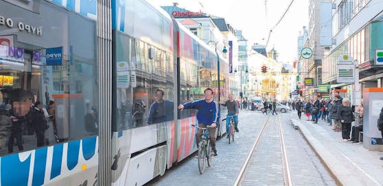 Zwei Radfahrer ließen sich in Linz von der fahrenden Bim ziehen.